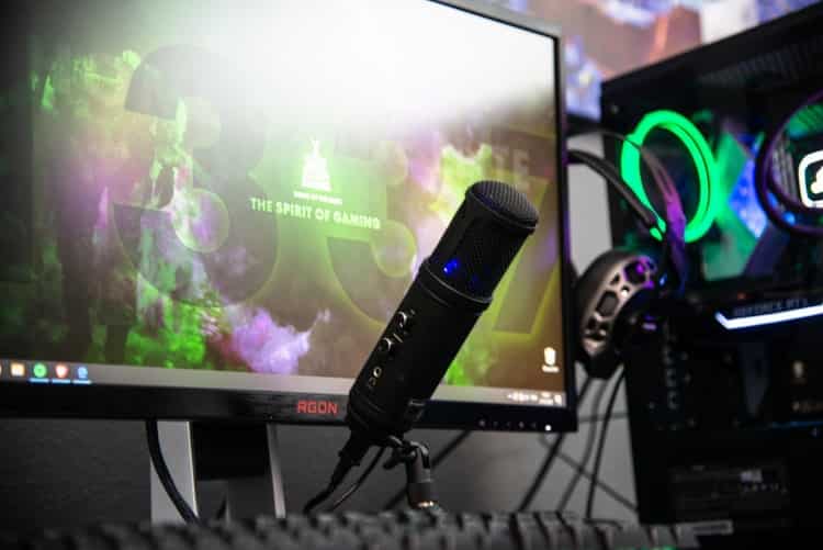 Monitor e microfone sobre a mesa tal qual um streamer de games utiliza
