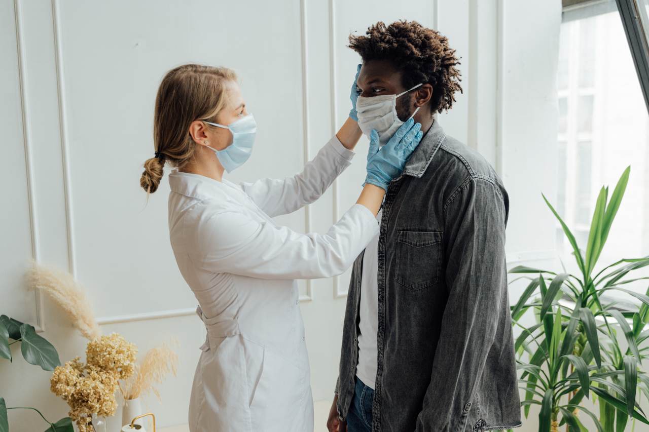 médica de jaleco coloca máscara em paciente