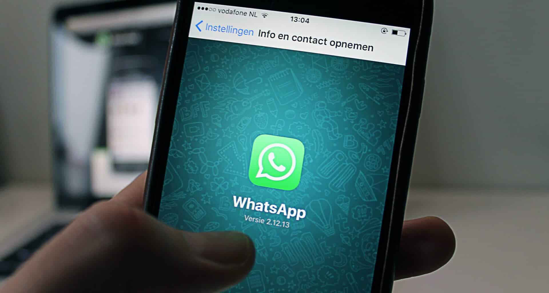 Mão segura celular que mostra ícone do WhatsApp na tela