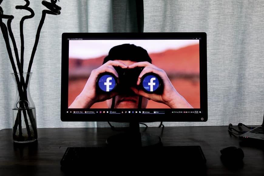 ilustração de binóculo com o logo do facebook na lente