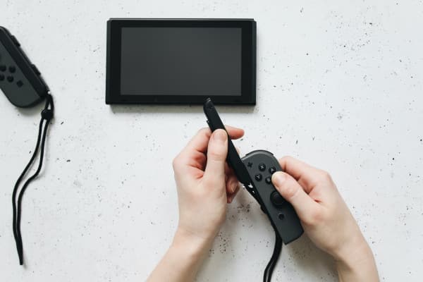 Nintendo switch nas mãos de uma pessoa.