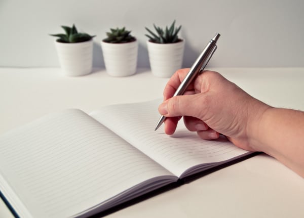 pessoa escrevendo no caderno em branco como pedir demissão